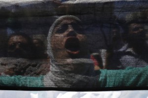 Protester holds a Palestinian flag and shouts anti-Israel slogans during a protest calling for an end to the Israeli air strikes in the Gaza Strip, near the Israeli embassy in Amman