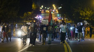 Demonstrators march in the street while protesting the shooting death of black teenager Michael Brown in Ferguson