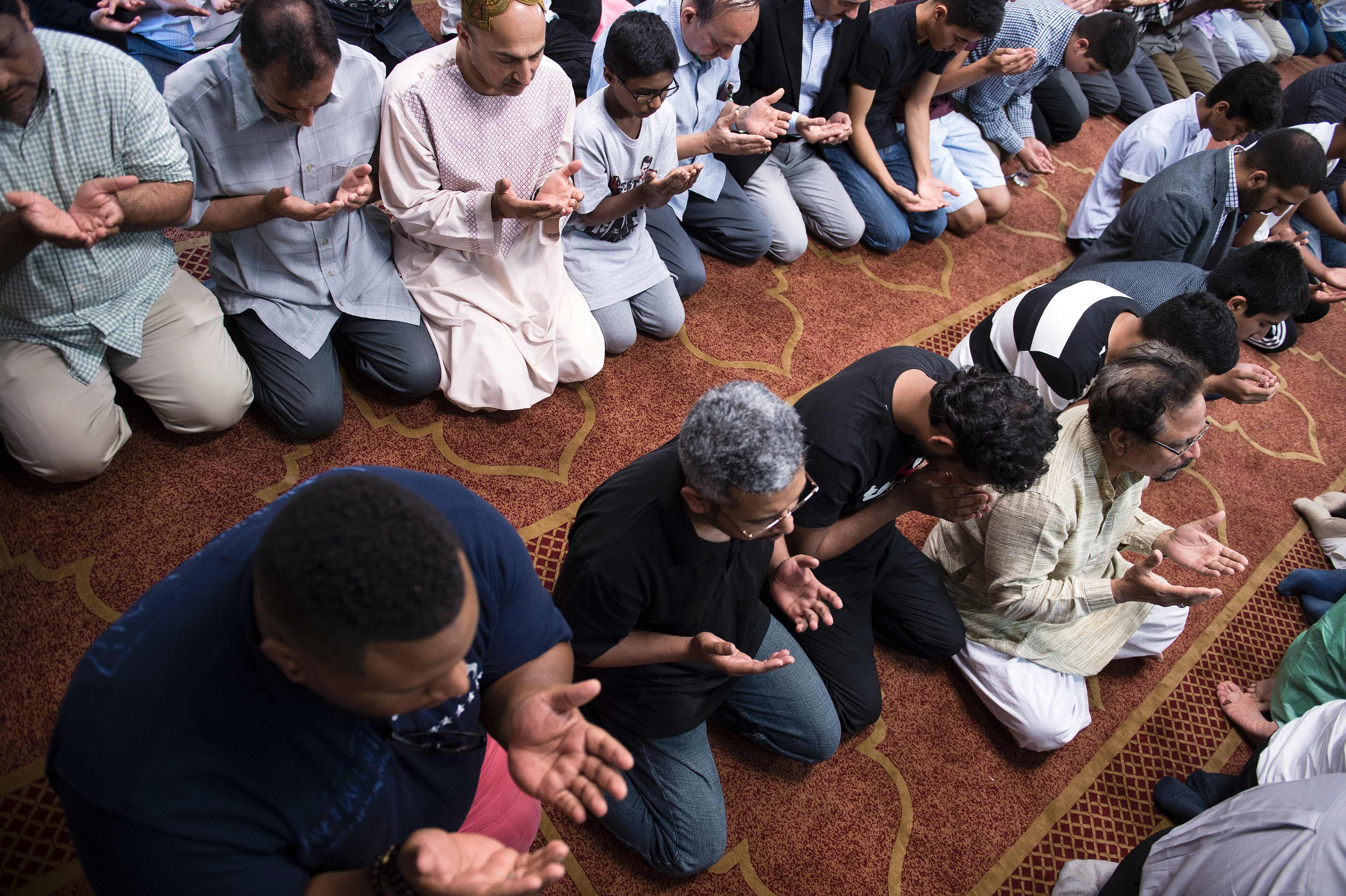 Muslims recite their late afternoon prayers during an interfaith service at the Louisville Islamic Center in honor of boxing legend Muhammad Ali June 5, 2016 in Louisville, Kentucky. The charismatic Ali, a dazzling fighter and outspoken civil rights activist who became one of the 20th century's most towering figures, died on June 3, 2016 at age 74 after health problems complicated by a long battle with Parkinson's disease. / AFP / Brendan Smialowski