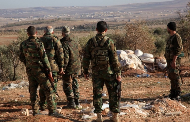 Syrian government forces monitor an area near the village of Khan Tuman, south from the provincial capital Aleppo, on December 22, 2015, two days after army units and other pro-regime forces recaptured several areas in the north of the country from Islamist forces, including Al-Qaeda's Syrian branch, Al-Nusra Front and Ahrar al-Sham brigade. Khan Tuman was the scene of fierce clashes between loyalist forces, including fighters of Lebanon's Shiite militia Hezbollah, and Islamist rebels, said the Syrian Observatory for Human Rights.  AFP PHOTO / GEORGE OURFALIAN / AFP PHOTO / GEORGE OURFALIAN